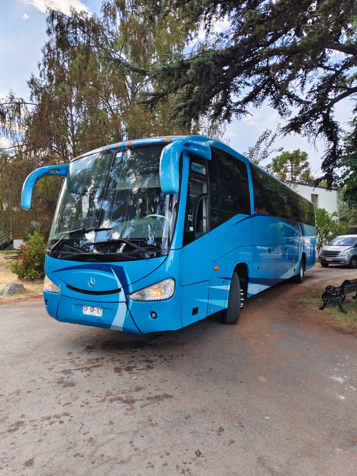 Bus de Transportes Jireh estacionado bajo árboles
