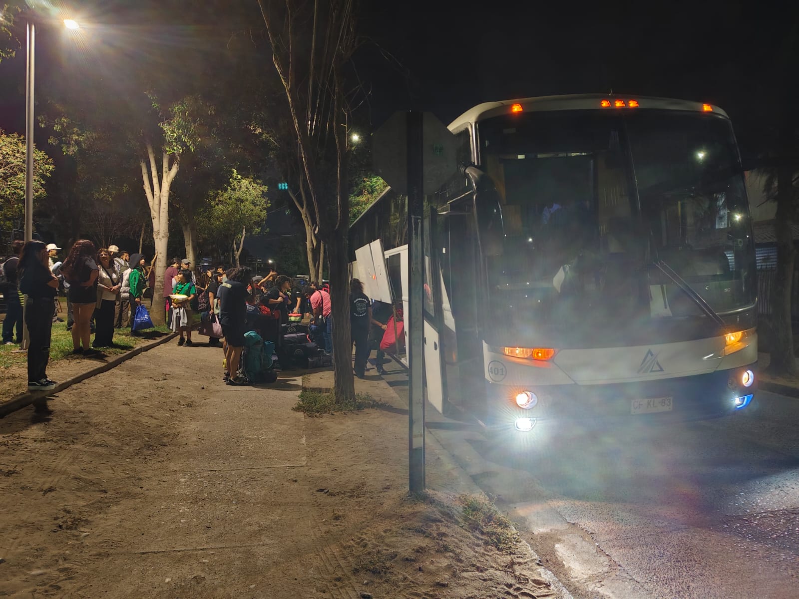 Estudiantes esperando junto al bus para iniciar una gira nocturna