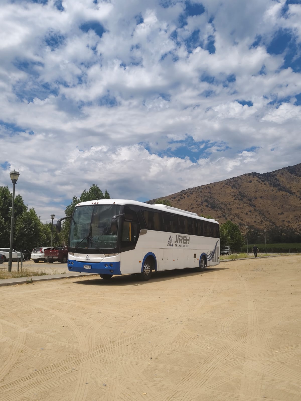 Bus de Transportes Jireh en un camino rural, con la cordillera de fondo