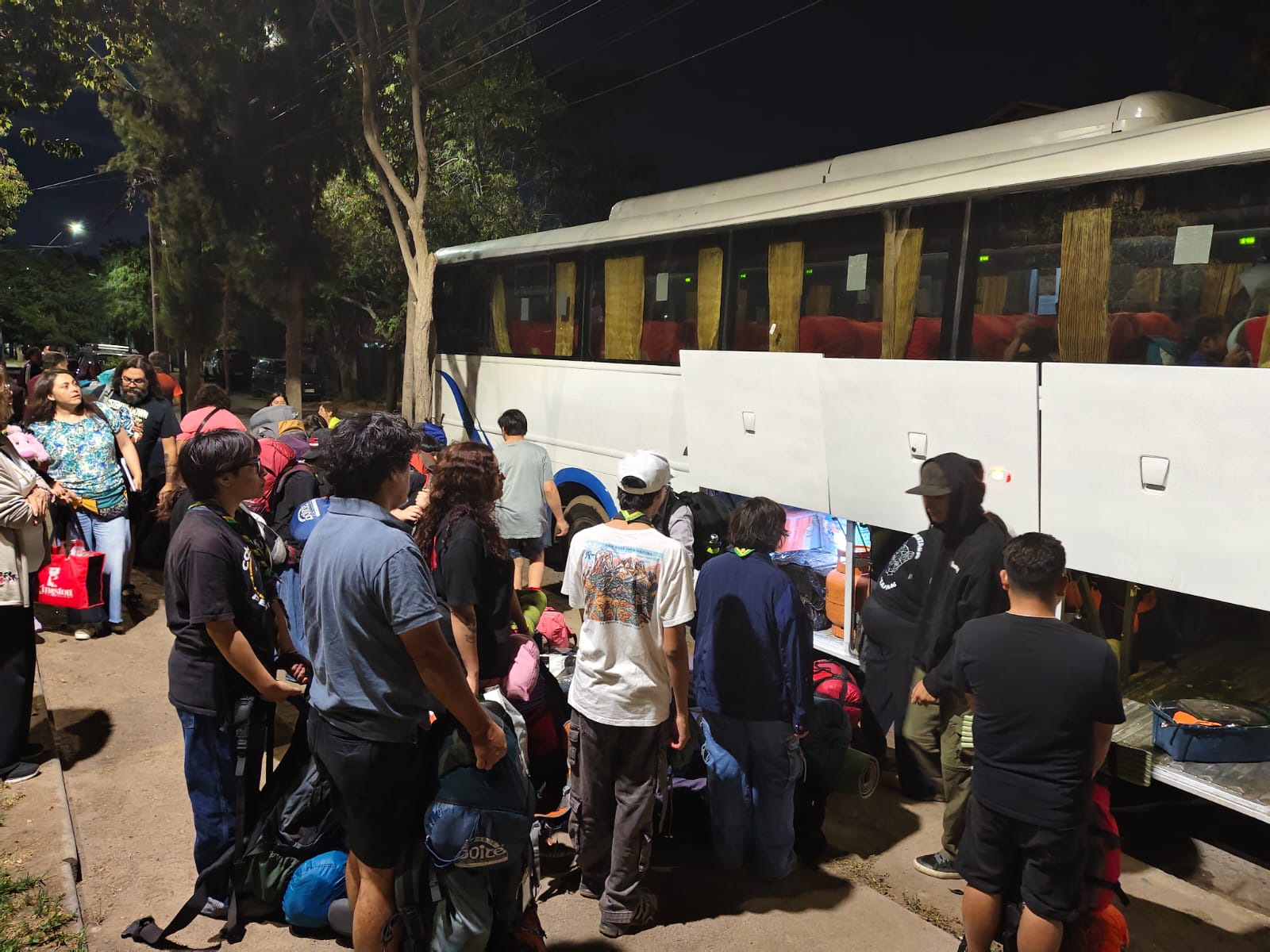 Estudiantes con mochilas subiendo al bus antes de salir de gira