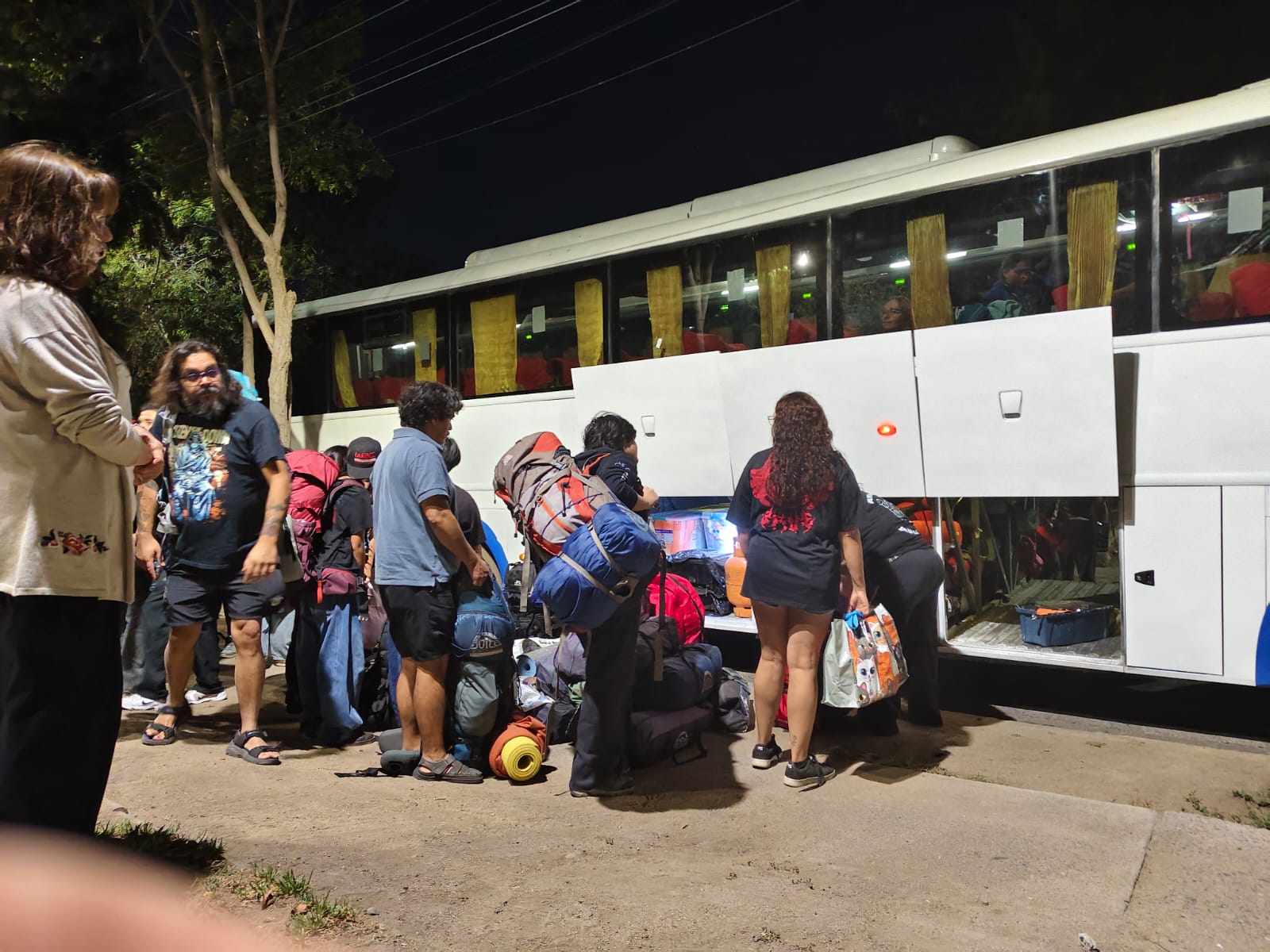 Equipaje y mochilas siendo acomodados en la bodega del bus